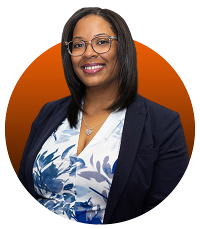 A woman in glasses and a jacket standing in front of an orange background.