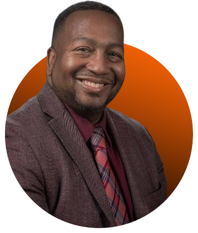 A man in a suit and tie smiling for the camera.