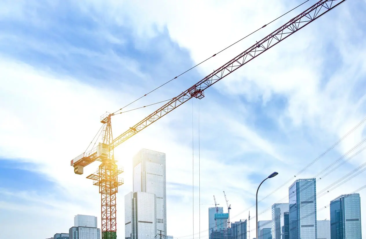 A crane is in the sky over some buildings.