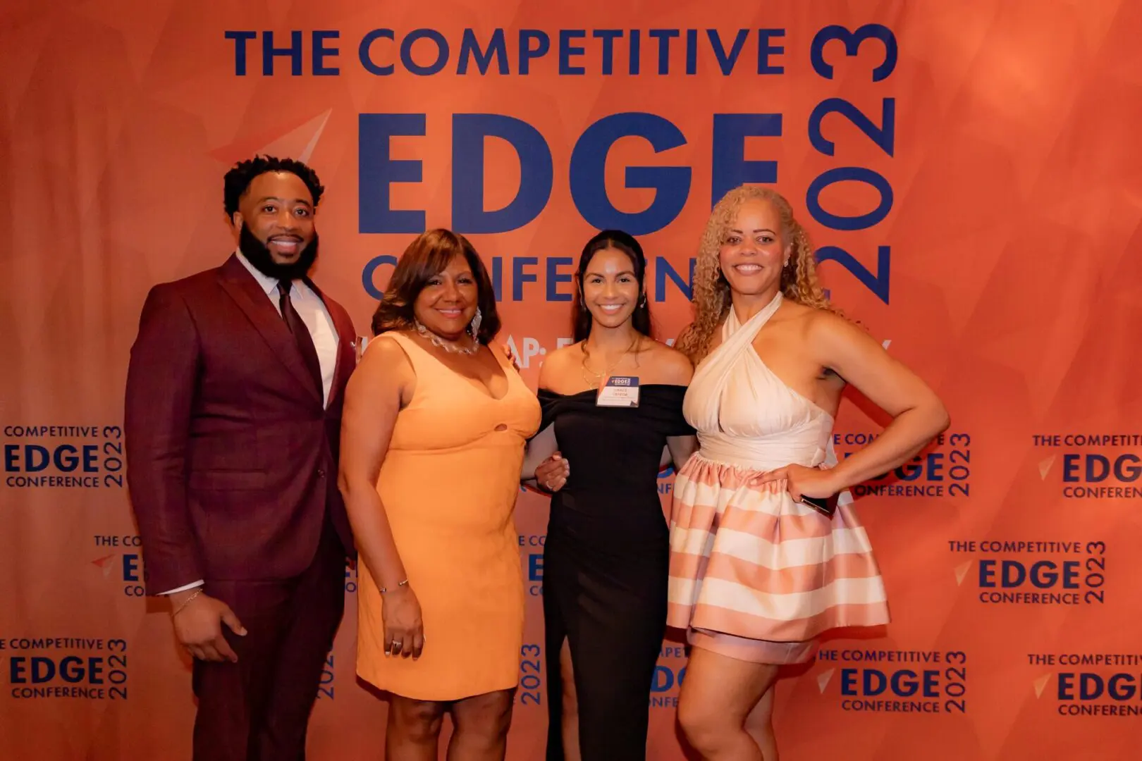 A group of people standing in front of the edge conference logo.