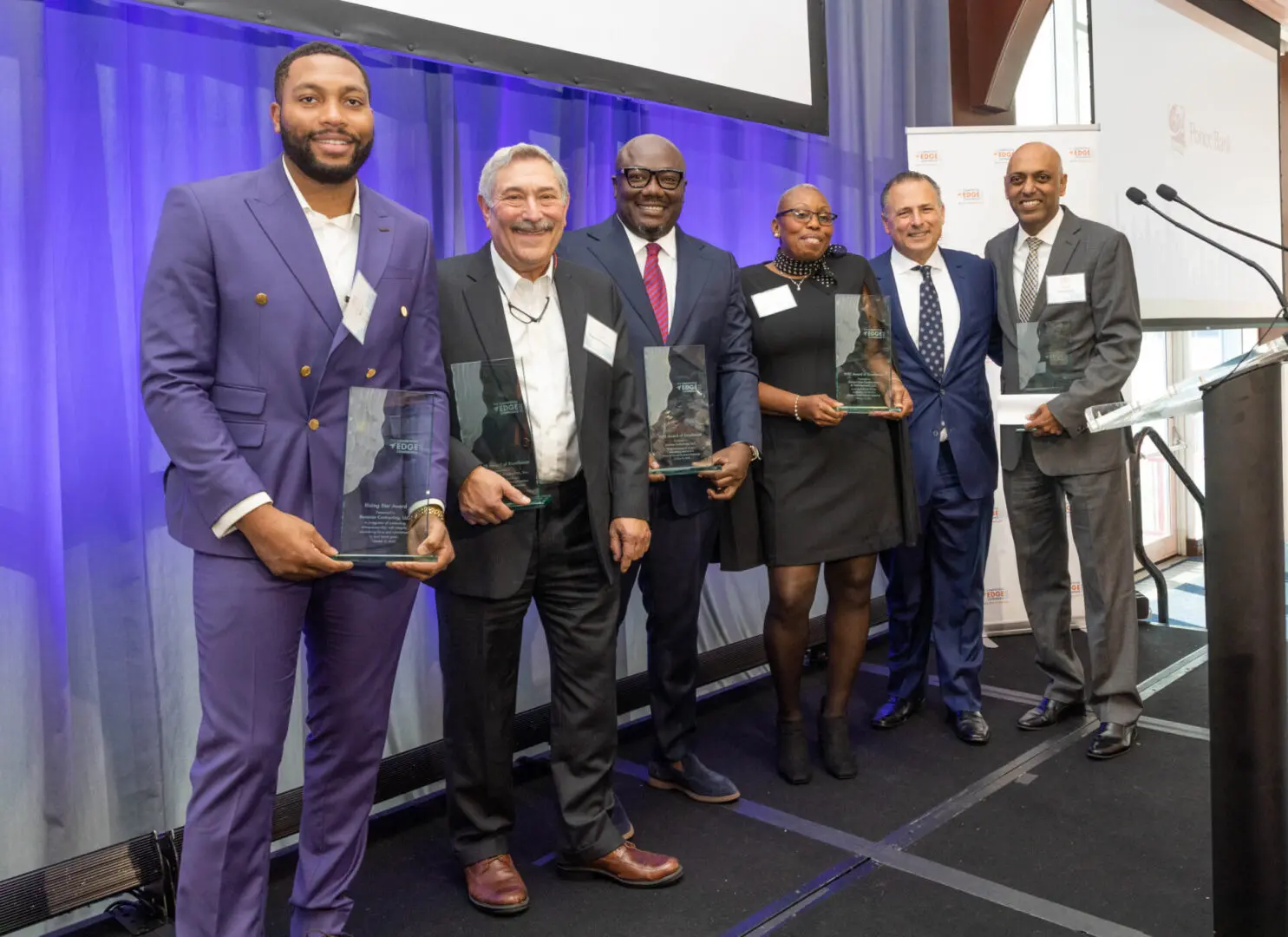 A group of people holding awards at an event.