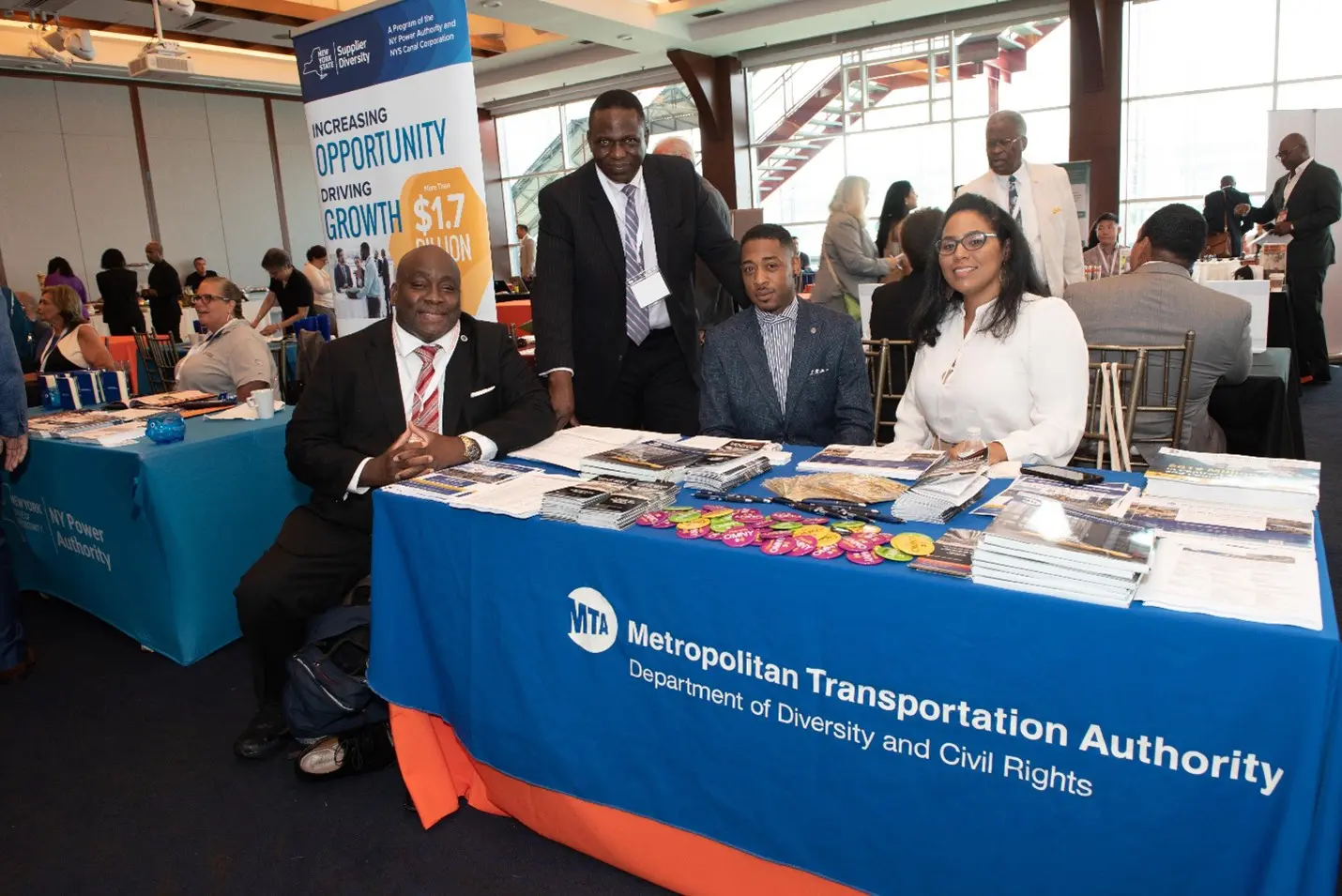 A group of people sitting at a table with an advertisement.